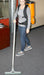 Person using a backpack vacuum cleaner on a carpeted floor.